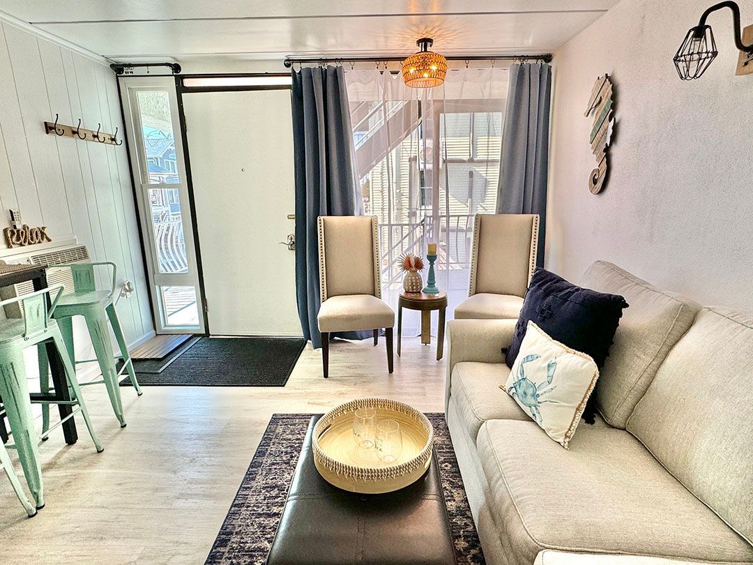 A living room with a couch, chairs, and a table.