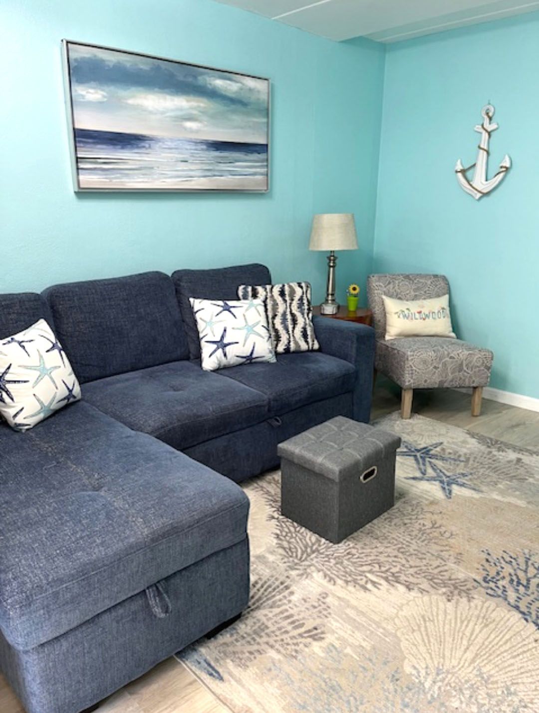 A living room with a blue sectional couch and a chair.