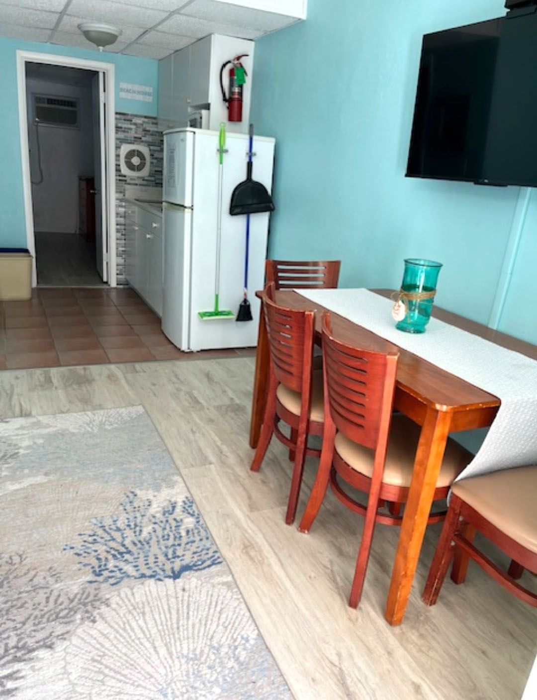 A dining room with a table and chairs and a refrigerator