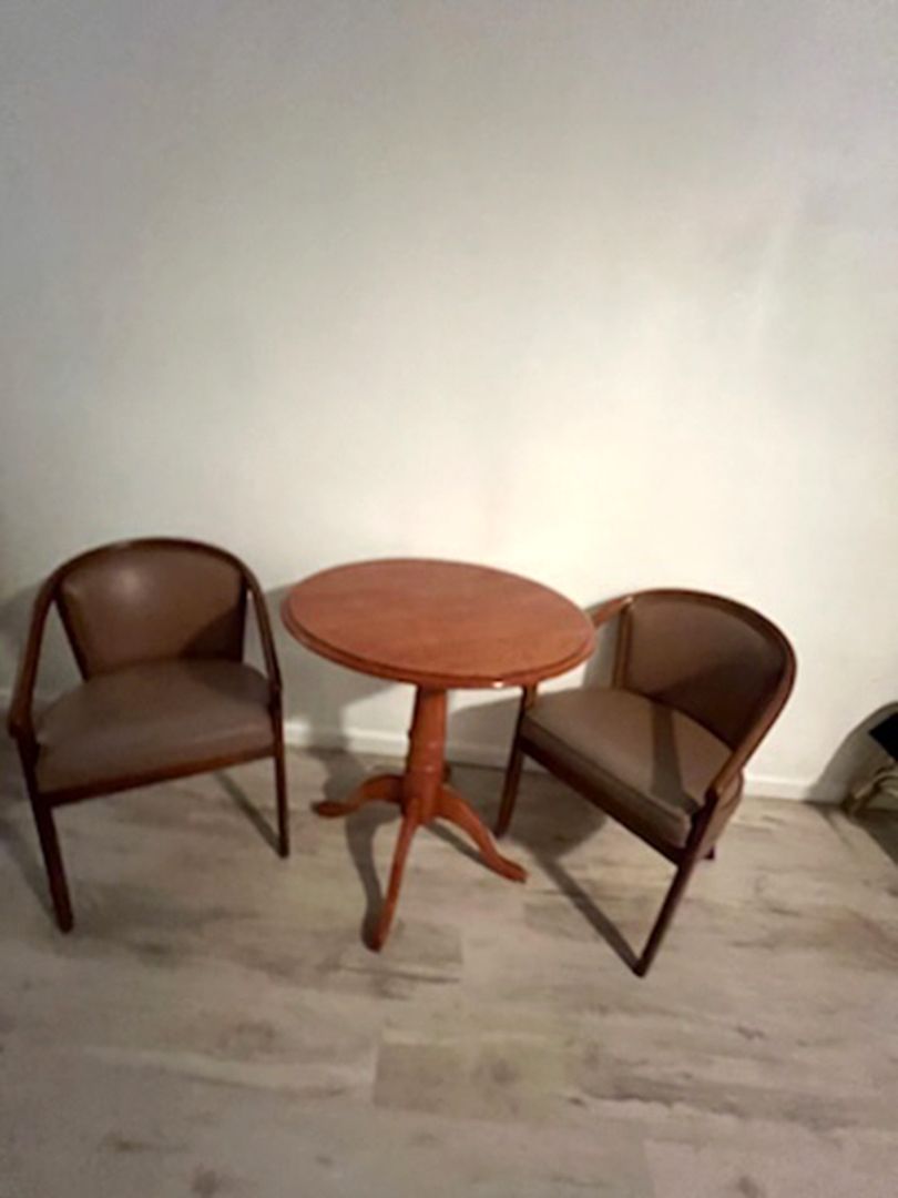 Two chairs are sitting next to a table in a room.