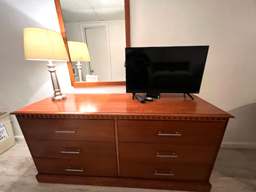 A dresser with drawers and a flat screen tv on it