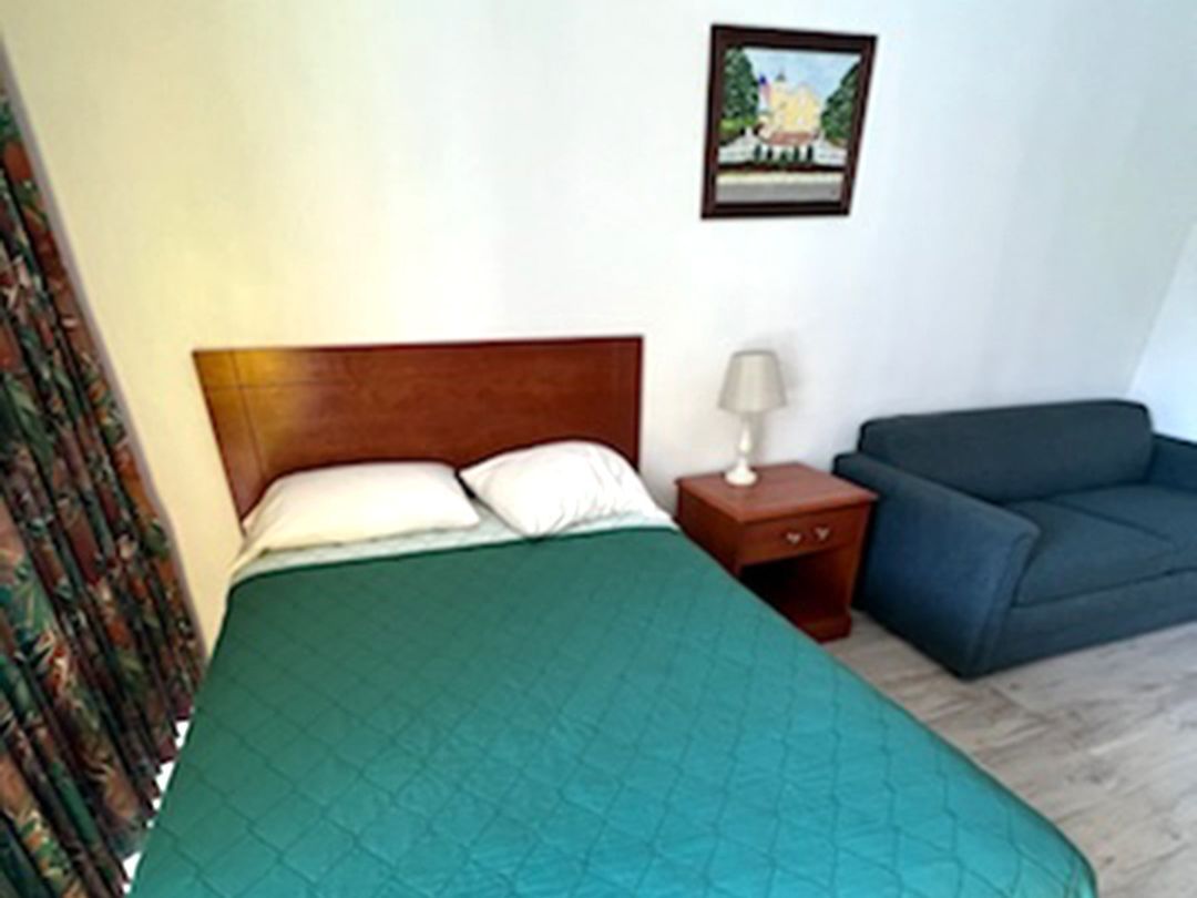 A hotel room with a bed and a couch