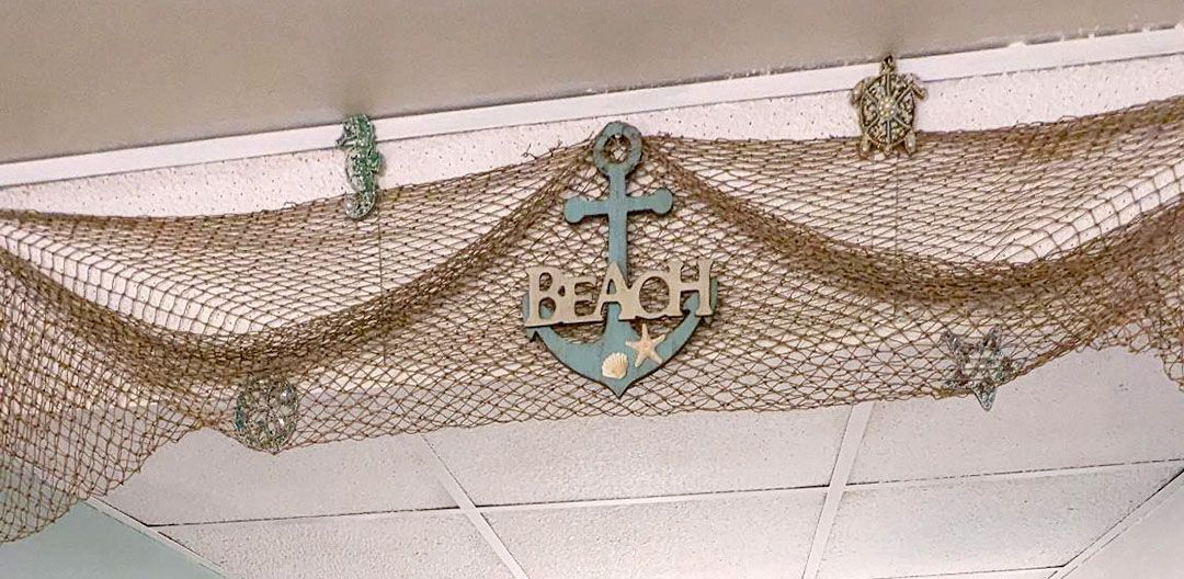 A blue anchor with the word beach written on it