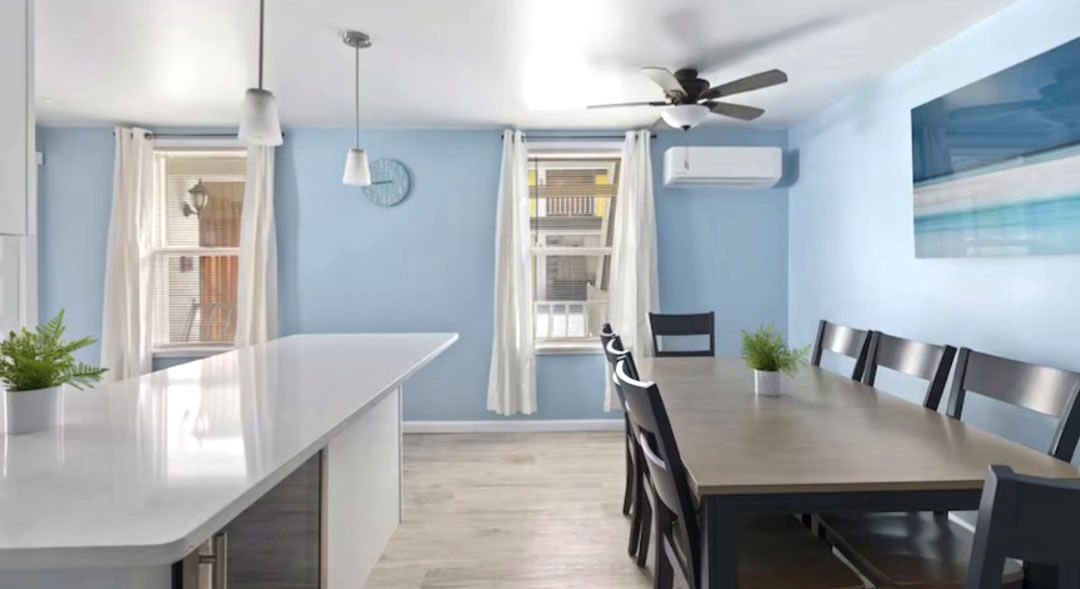 A kitchen with a table and chairs and a ceiling fan.