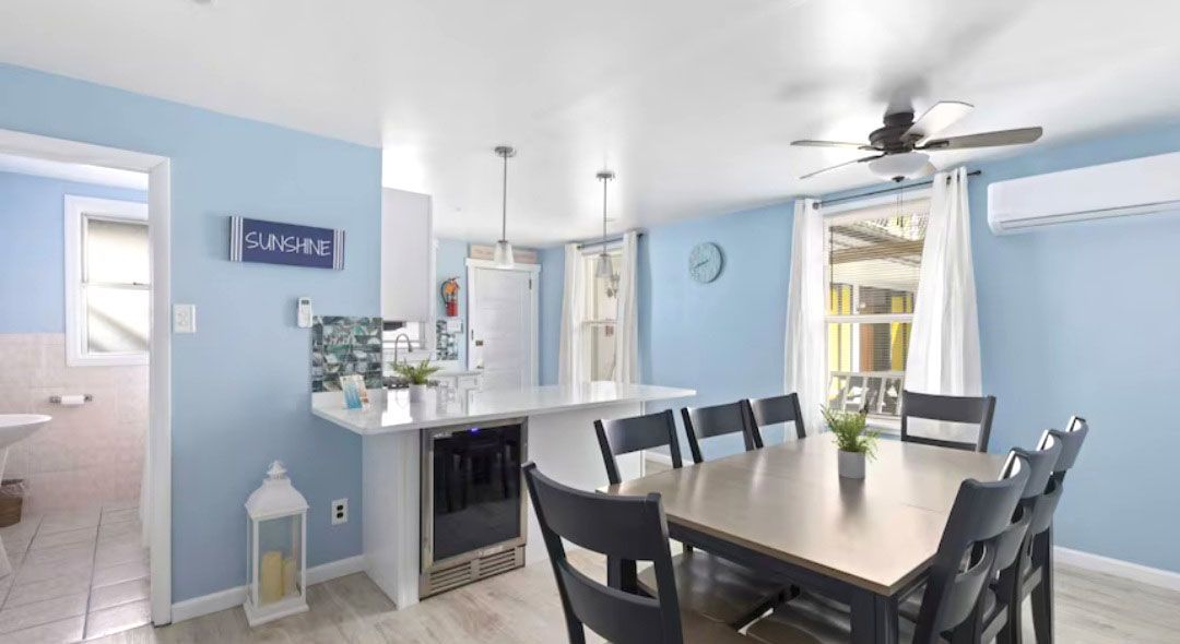 A dining room with a table and chairs and a ceiling fan.