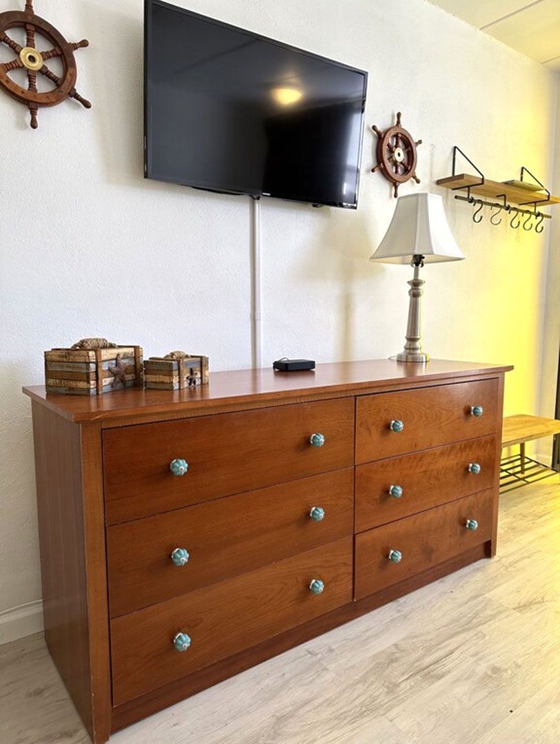 wooden drawers with a wall mounted television