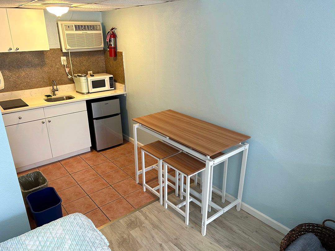A small kitchen with a table and stools in it