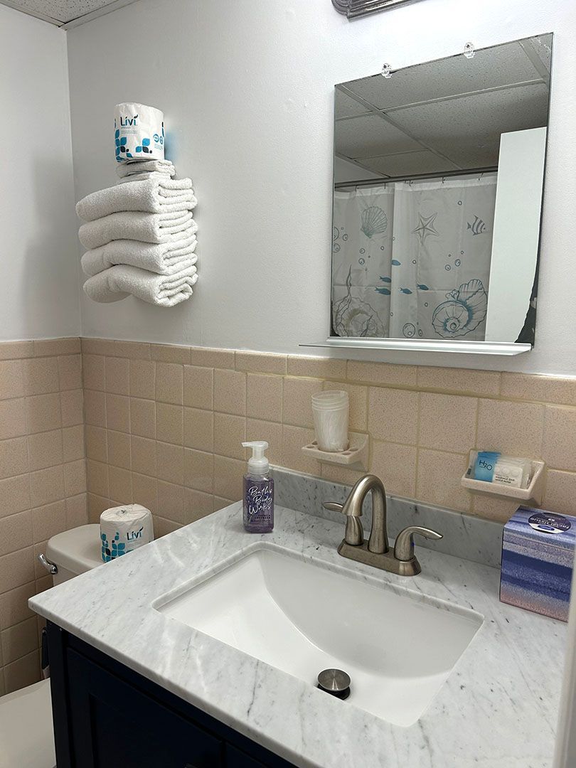 A bathroom with a sink, toilet, and mirror
