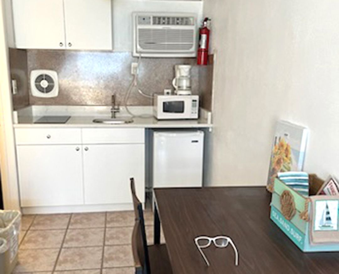 A kitchen with a table and chairs and a microwave