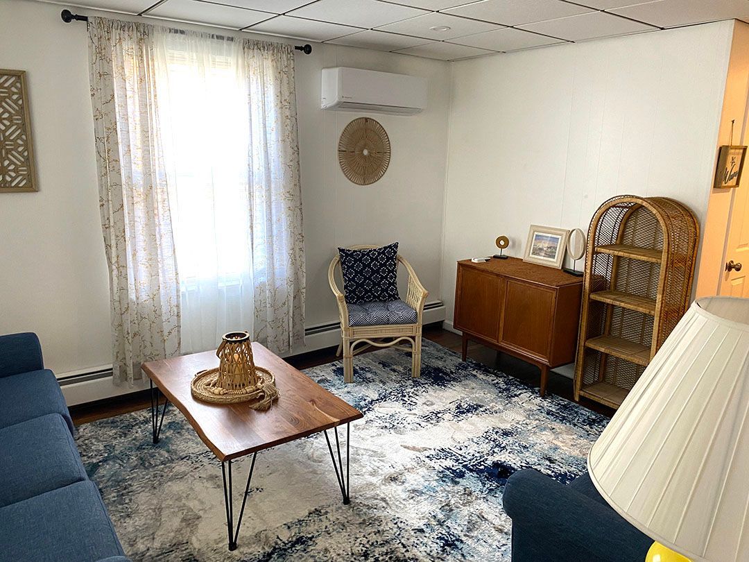 A living room with a couch, chair, coffee table, and lamp.