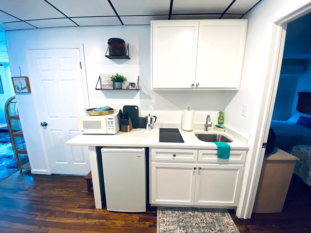 A small kitchen with white cabinets and a sink