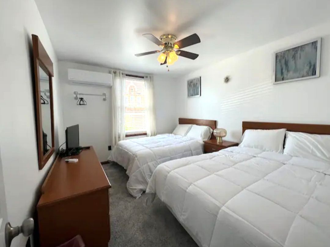 A hotel room with two beds and a ceiling fan