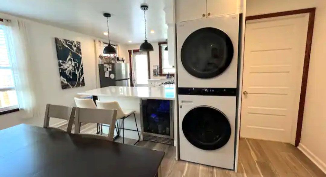 A washer and dryer are stacked on top of each other in a kitchen.