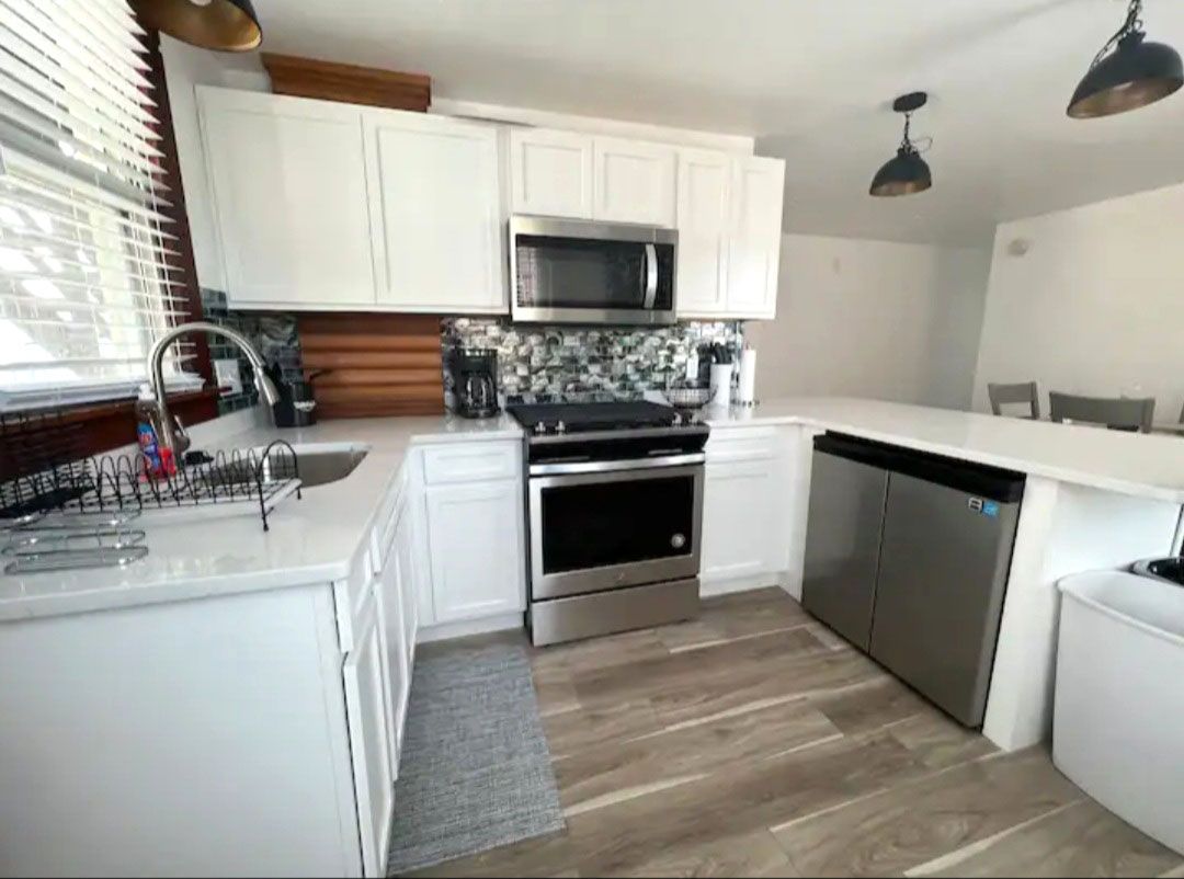 A kitchen with white cabinets and stainless steel appliances.