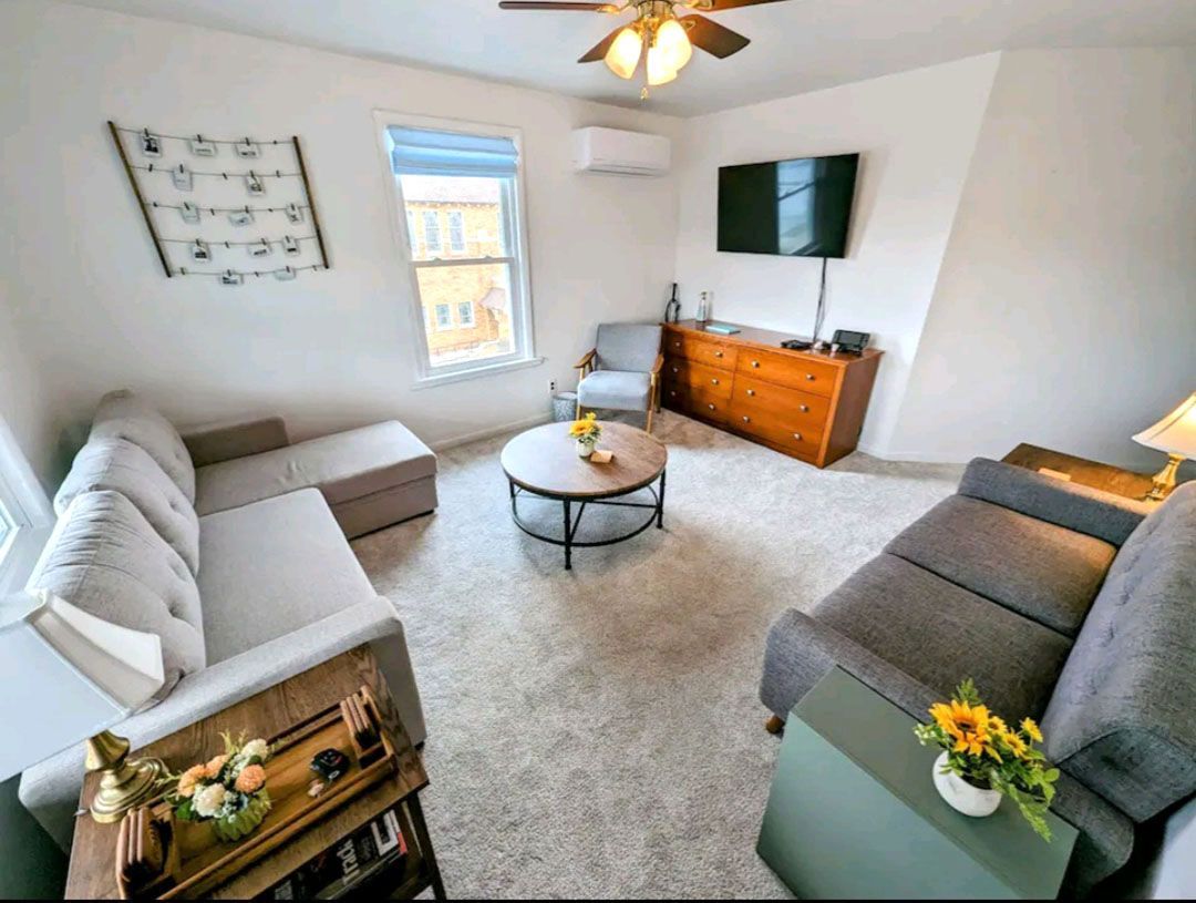 A living room with a couch, chair, coffee table, and television.