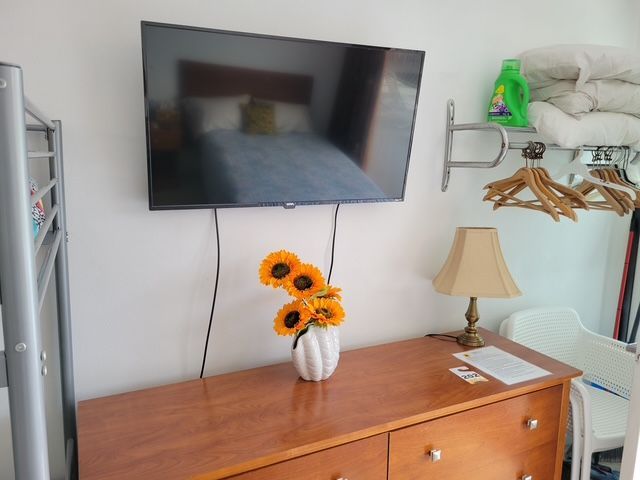 A bedroom with a dresser and a flat screen TV