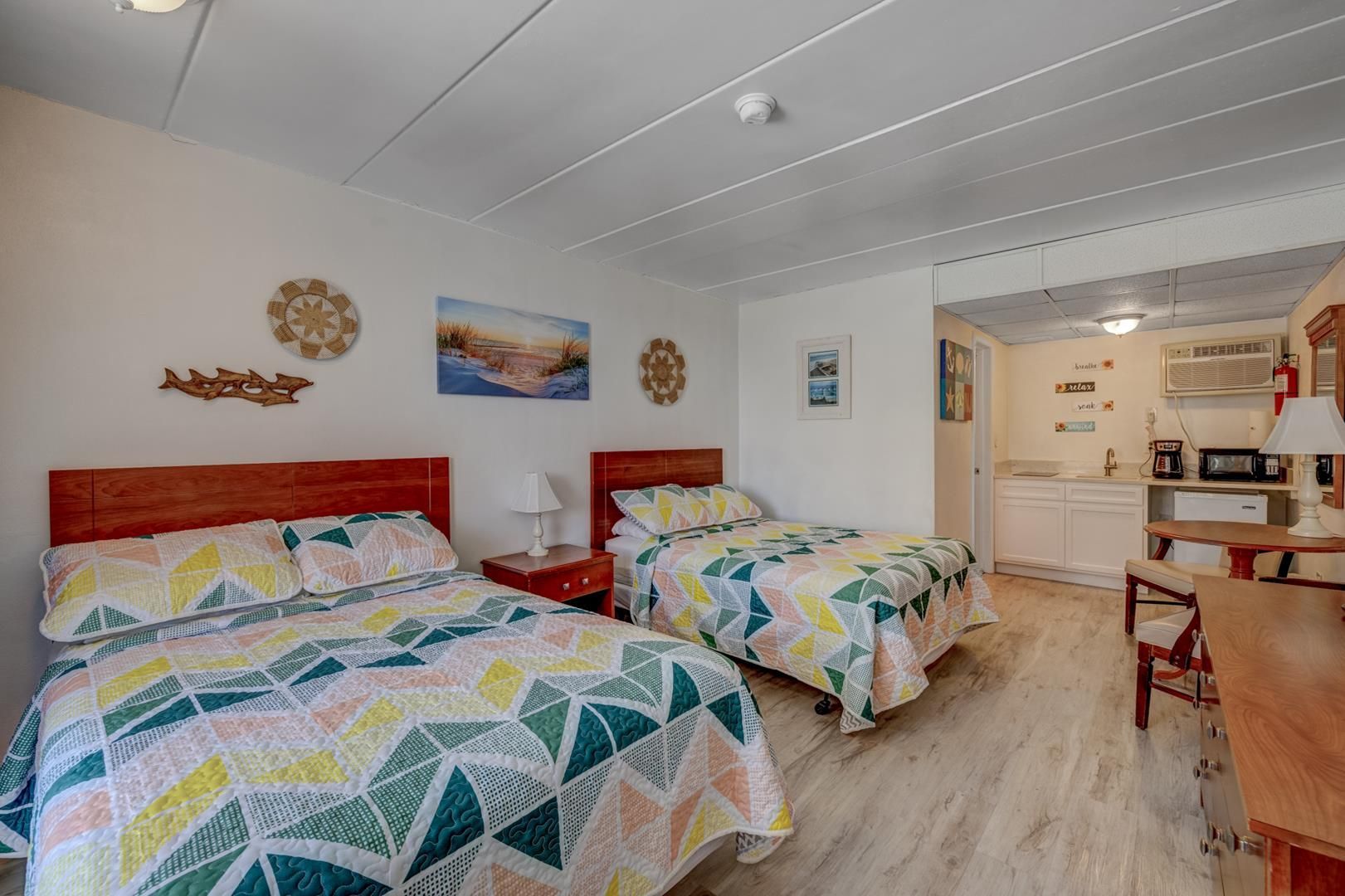 A hotel room with two beds and a kitchen