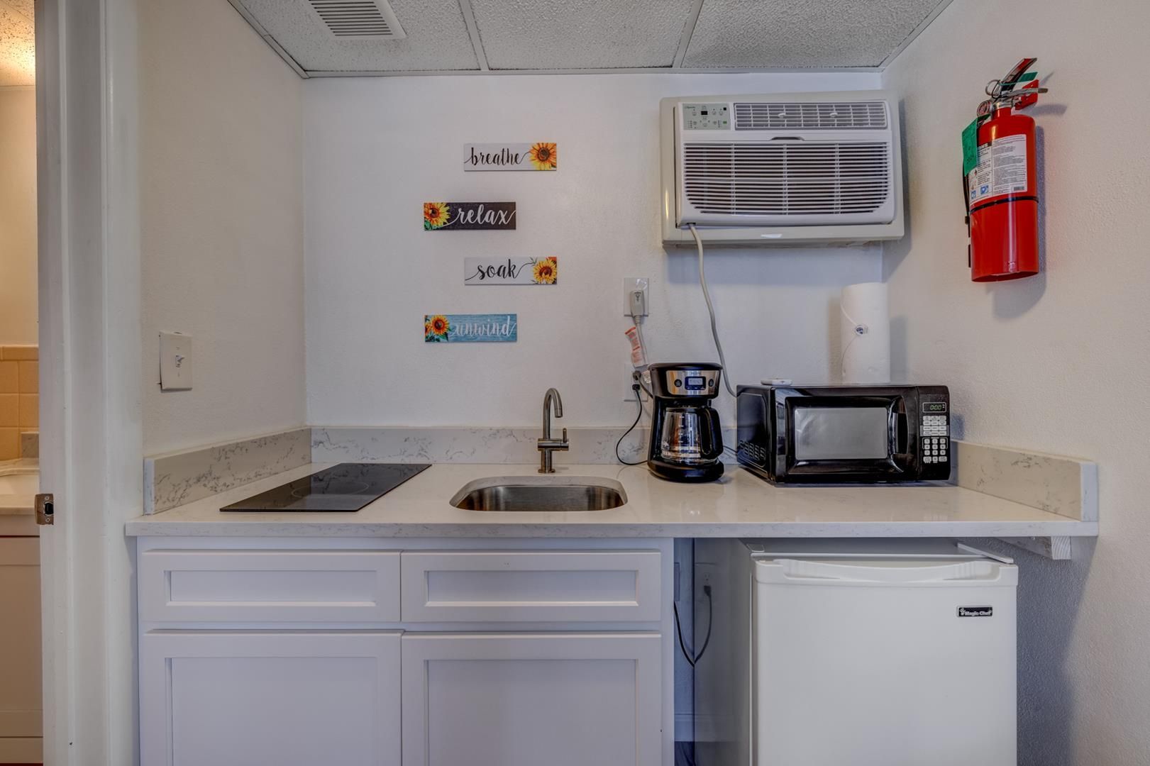 A small kitchen with a sink, microwave, and refrigerator.