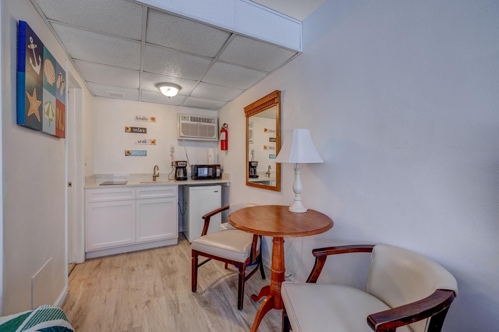 A small room with a table and chairs and a kitchen.
