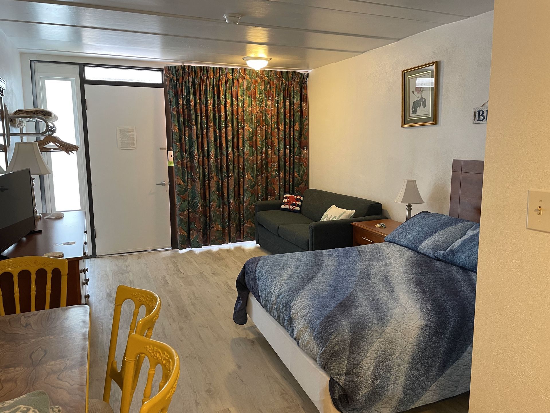 A bedroom with a bed, couch, table, and chairs