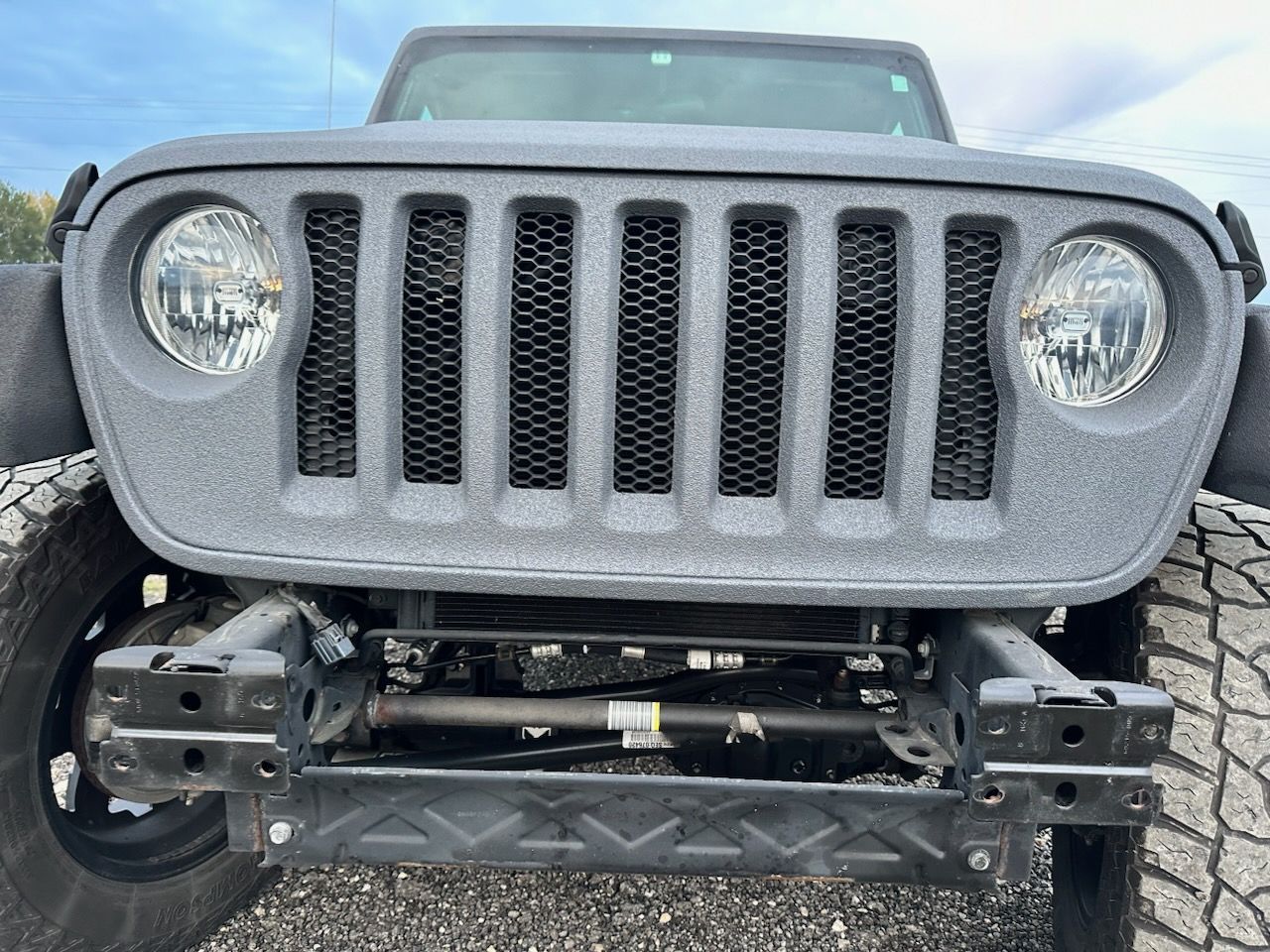 A close up of a jeep 's front bumper and grill.