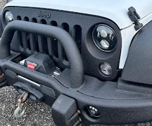 A close up of a jeep with a black bumper and grille.