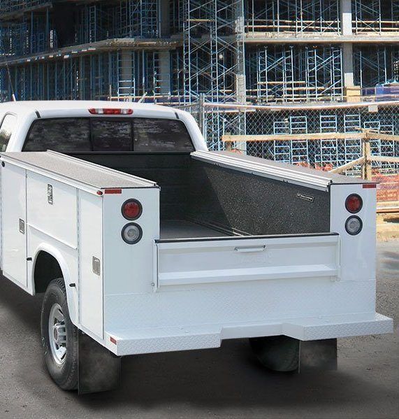 A white utility truck is parked in front of a construction site