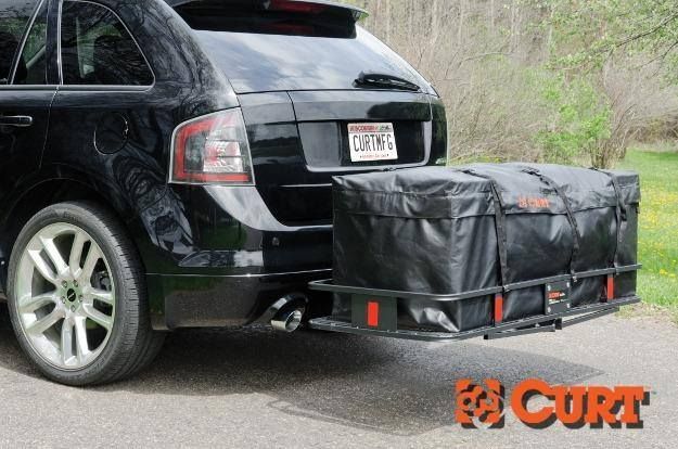 A black car with a large bag attached to the back of it