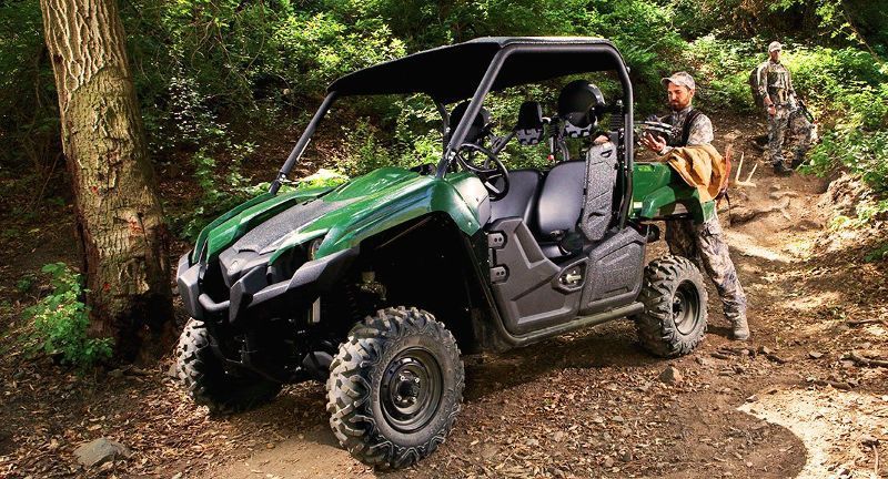 A green atv in the woods.