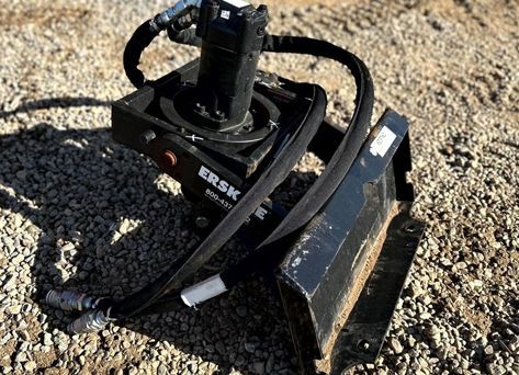 A black machine is sitting on top of a pile of gravel.