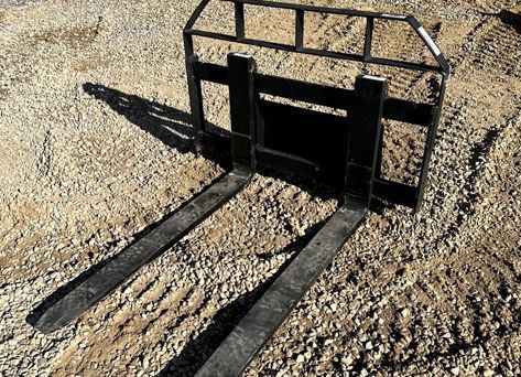 A pair of forks sitting on top of a pile of gravel.