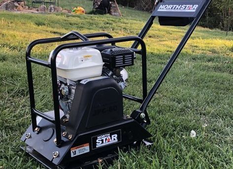 A north star vibratory plate compactor is sitting in the grass.