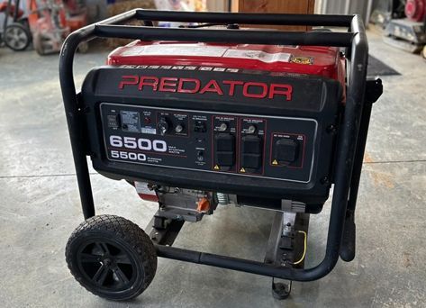 A predator generator is sitting on the ground in a garage