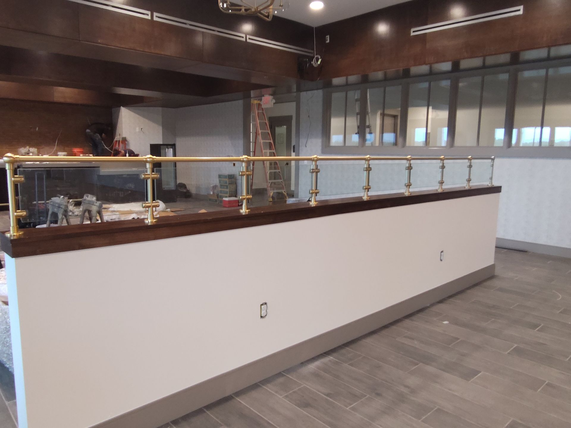A long counter in a restaurant with a brass railing.
