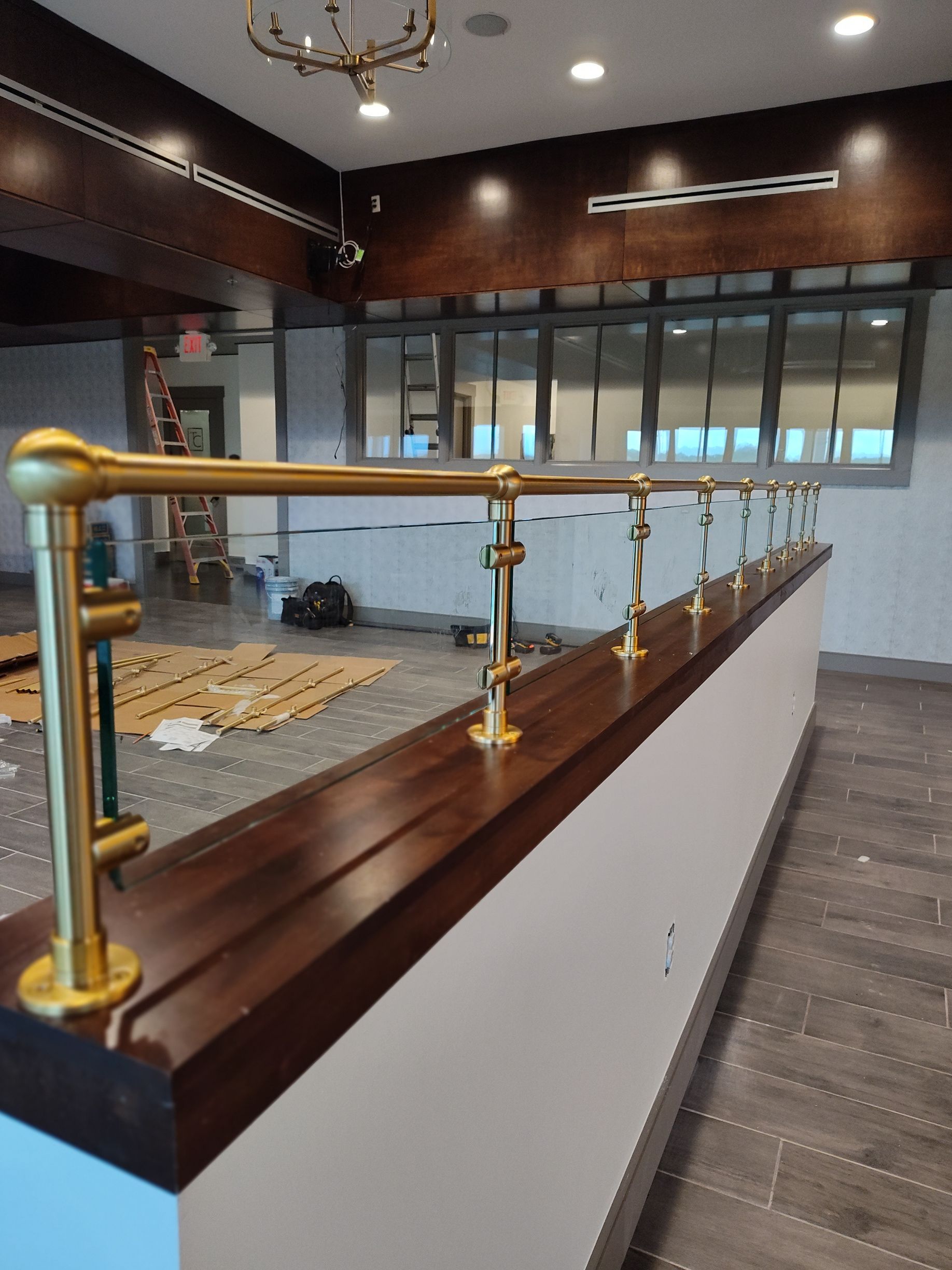 A room with a brass railing and a wooden counter top.