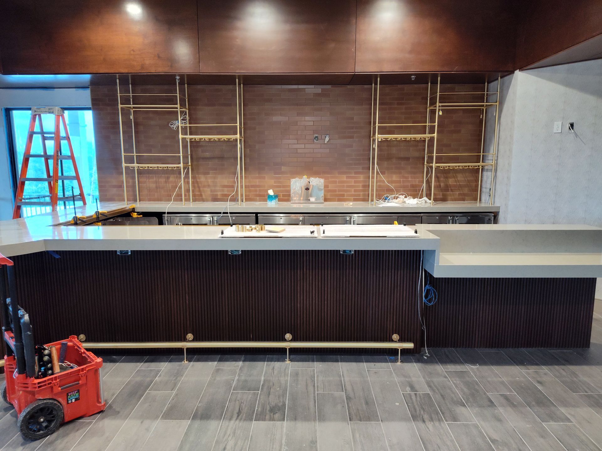 A bar is being built in a restaurant with a ladder in the background.