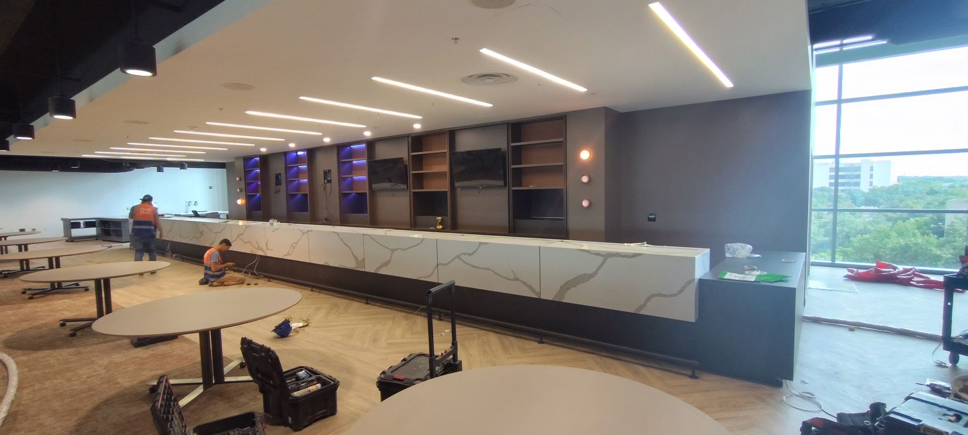 A large room with tables and chairs in it is being remodeled.