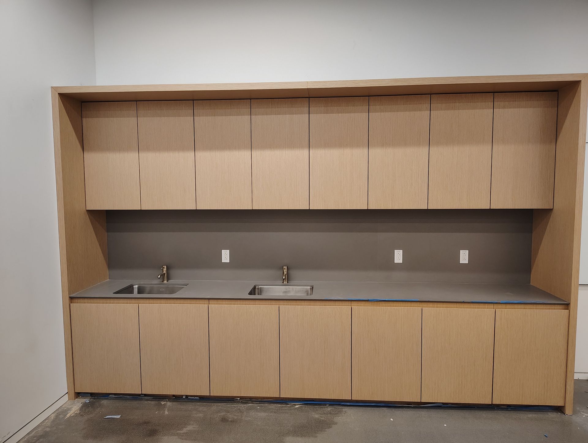 A long kitchen with wooden cabinets and a sink.