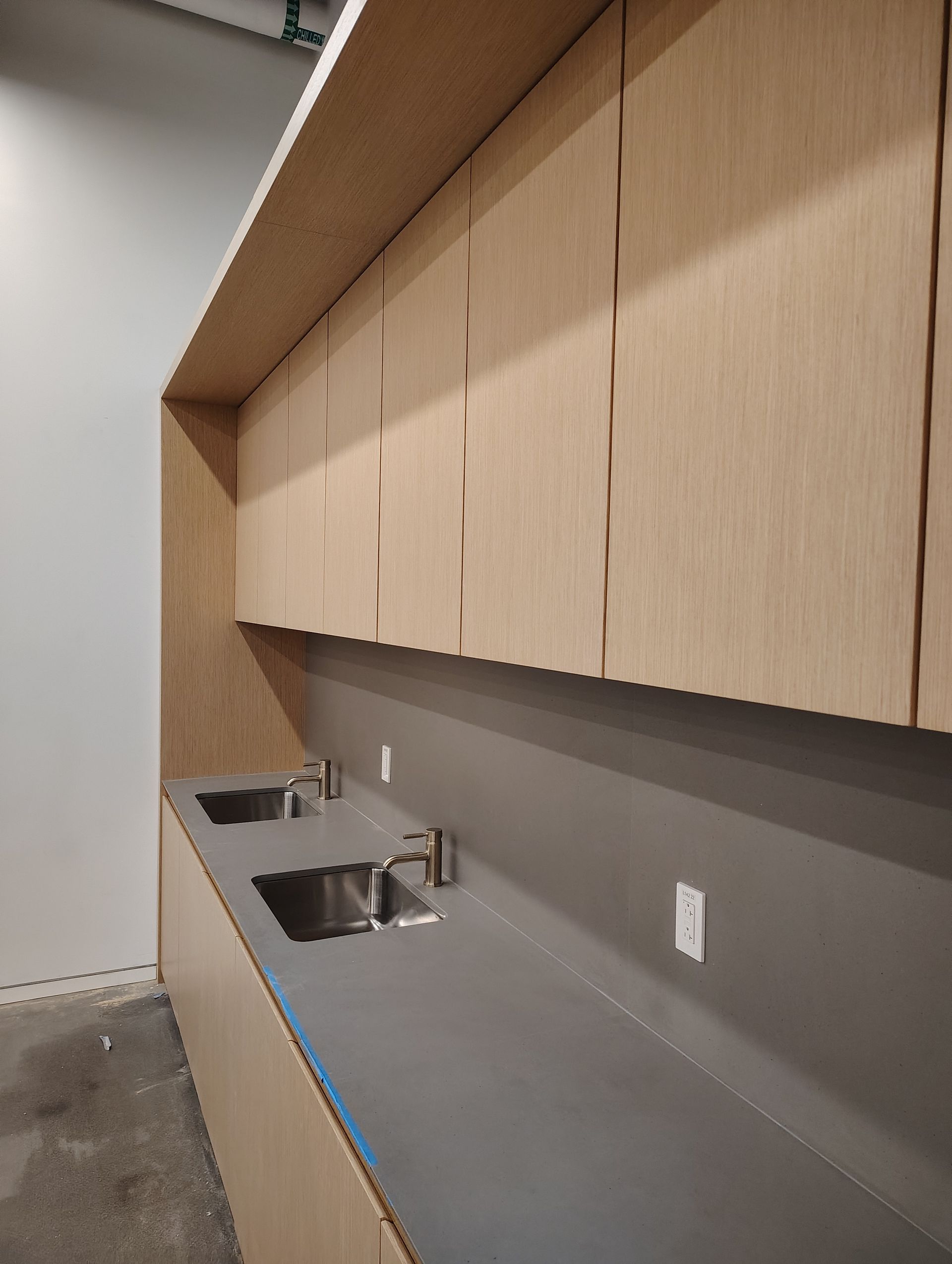 A kitchen with two sinks and wooden cabinets.