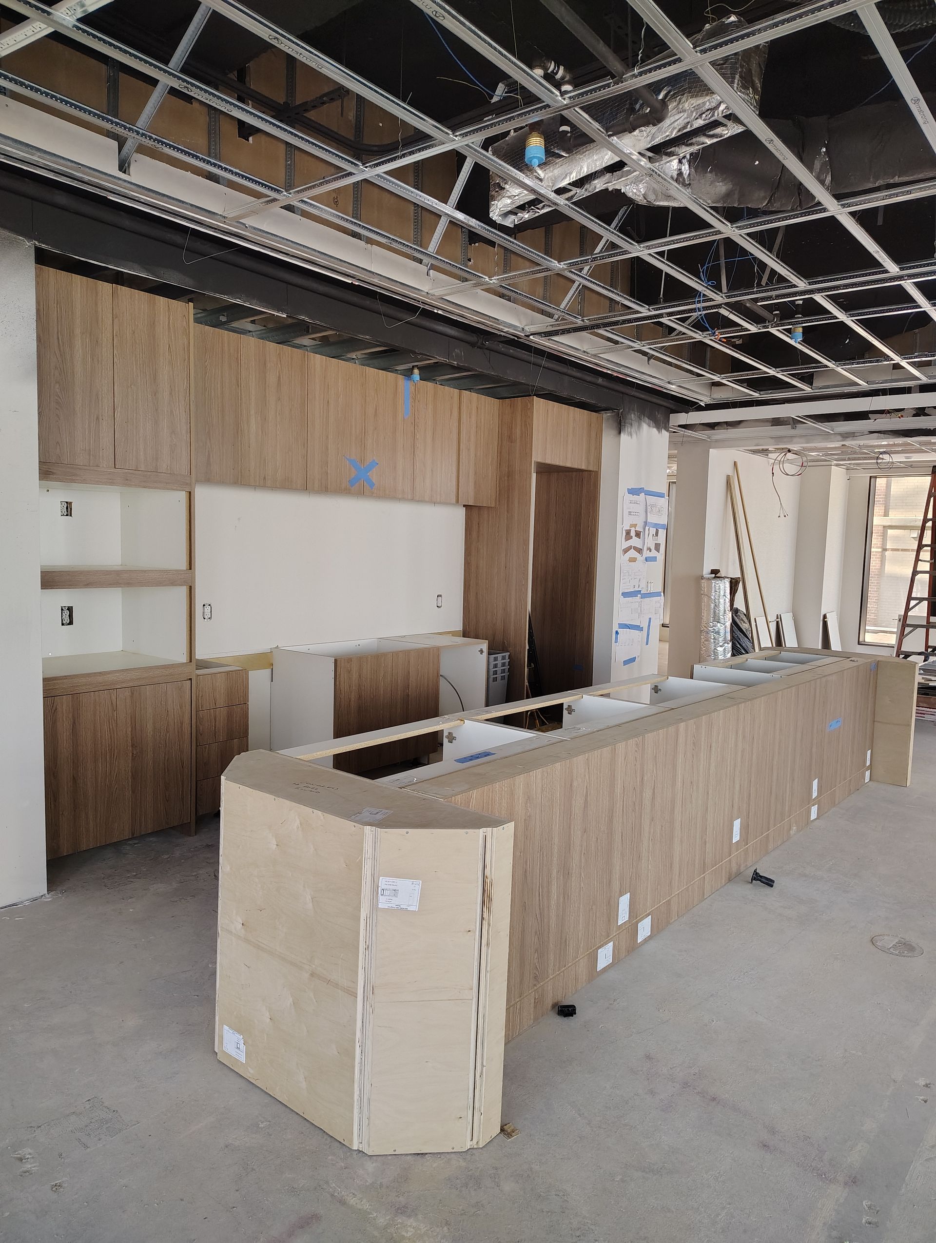 A long wooden counter in a kitchen under construction.