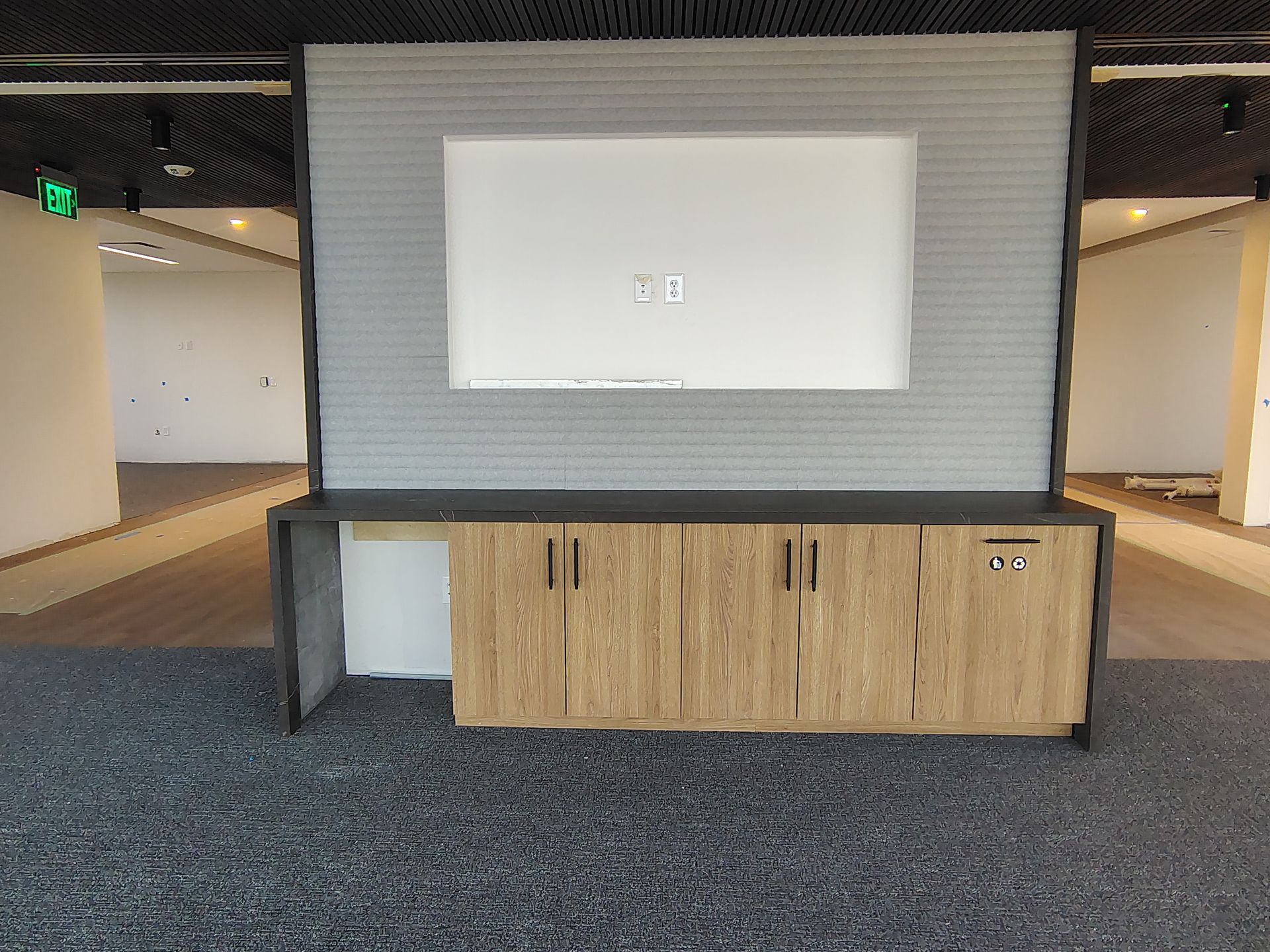 An empty room with a wooden cabinet and a flat screen tv on the wall.