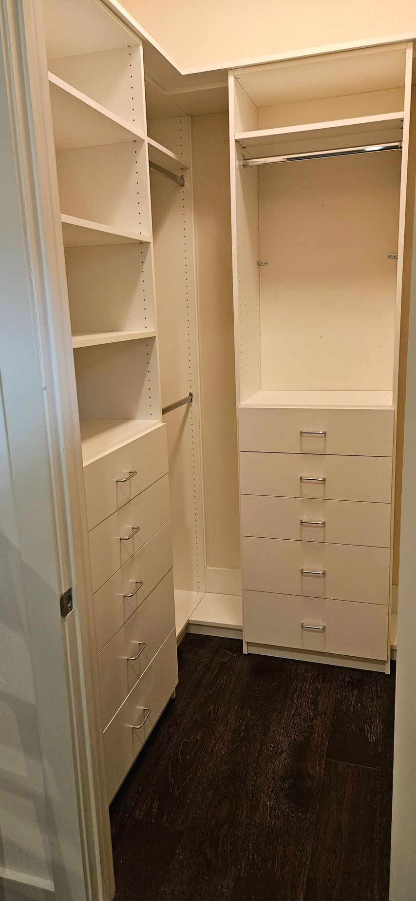 A walk in closet with lots of shelves and drawers.