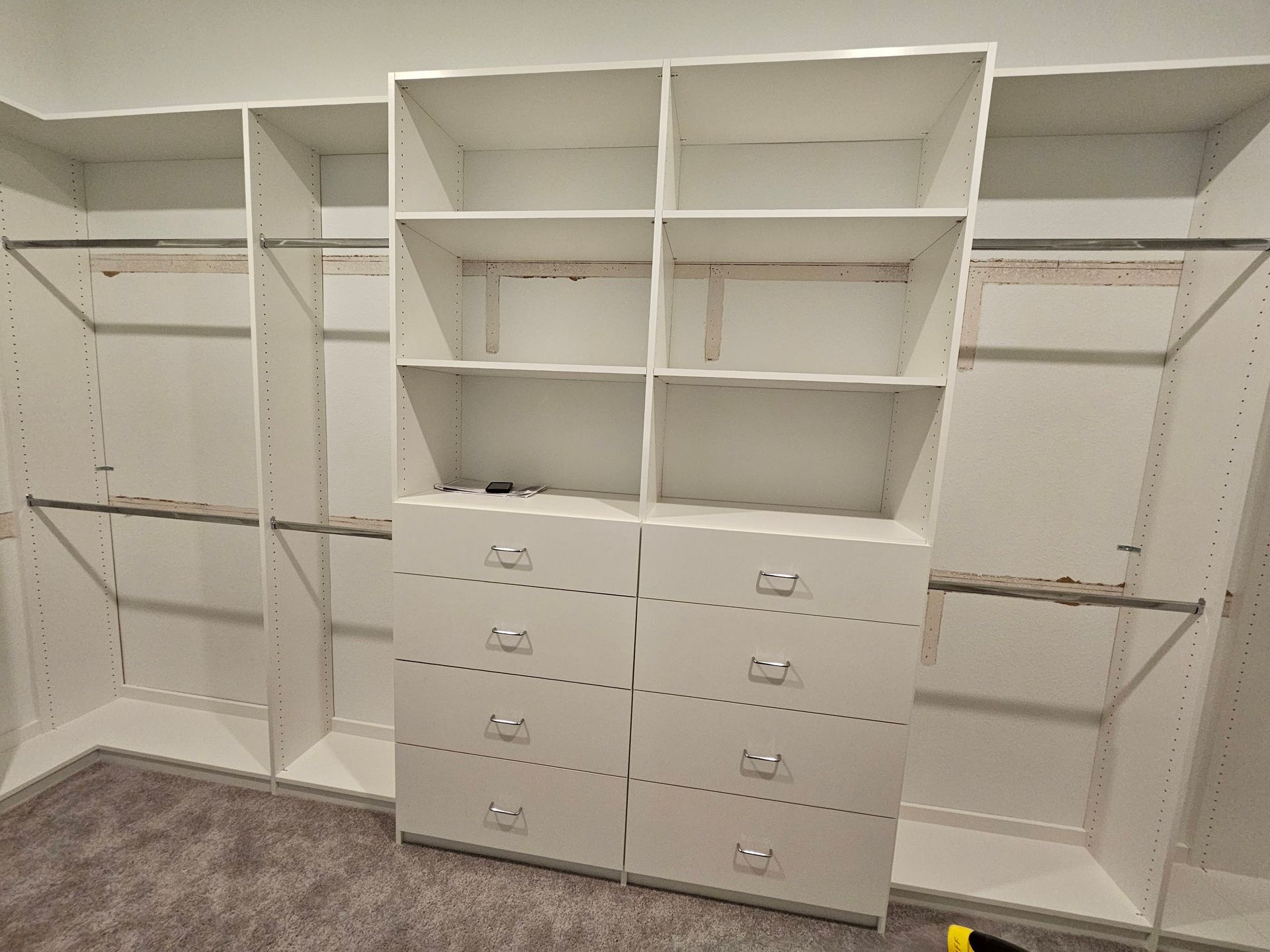 A walk in closet with lots of shelves and drawers.