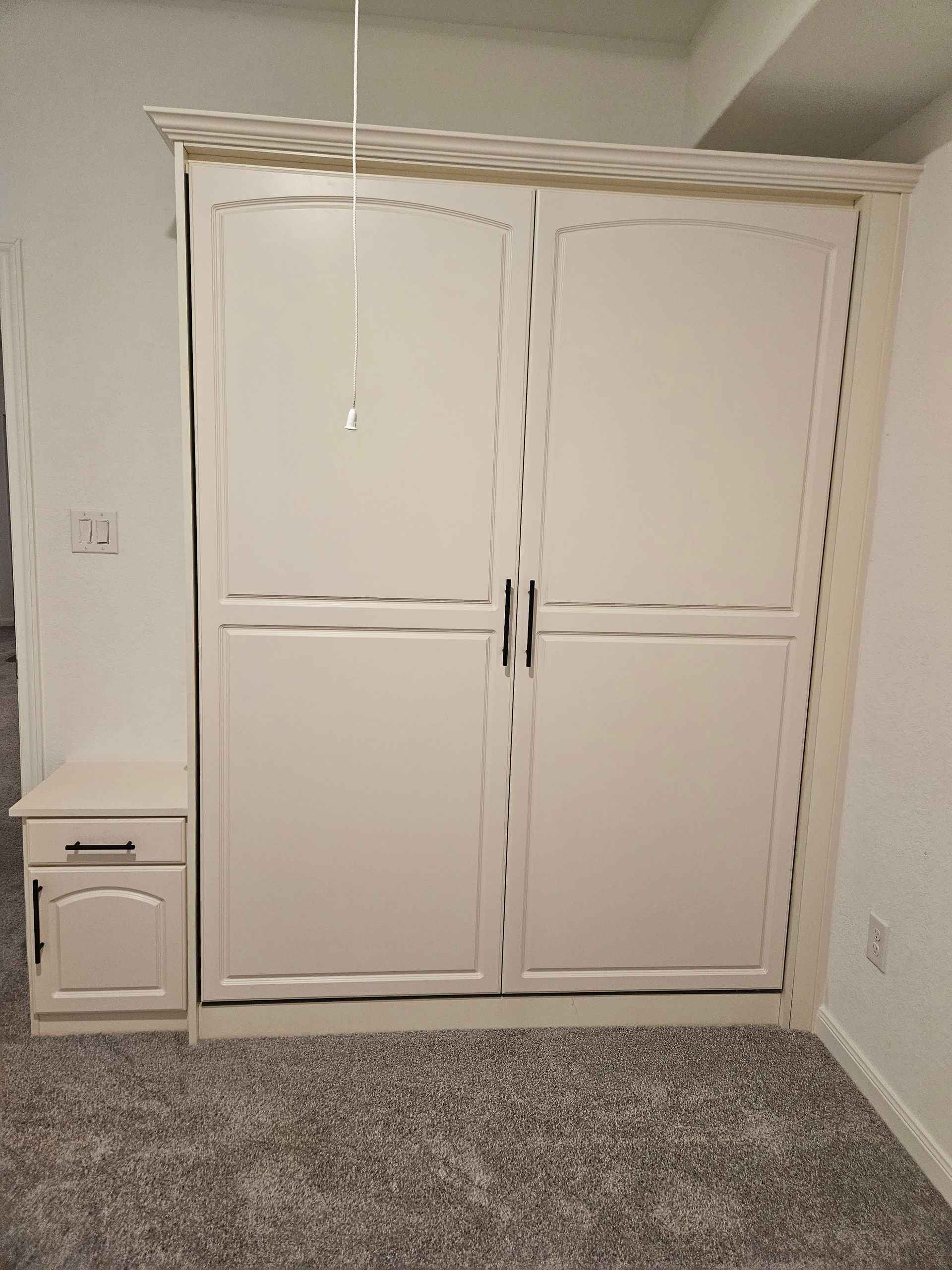 A bedroom with a closet and a nightstand in it.
