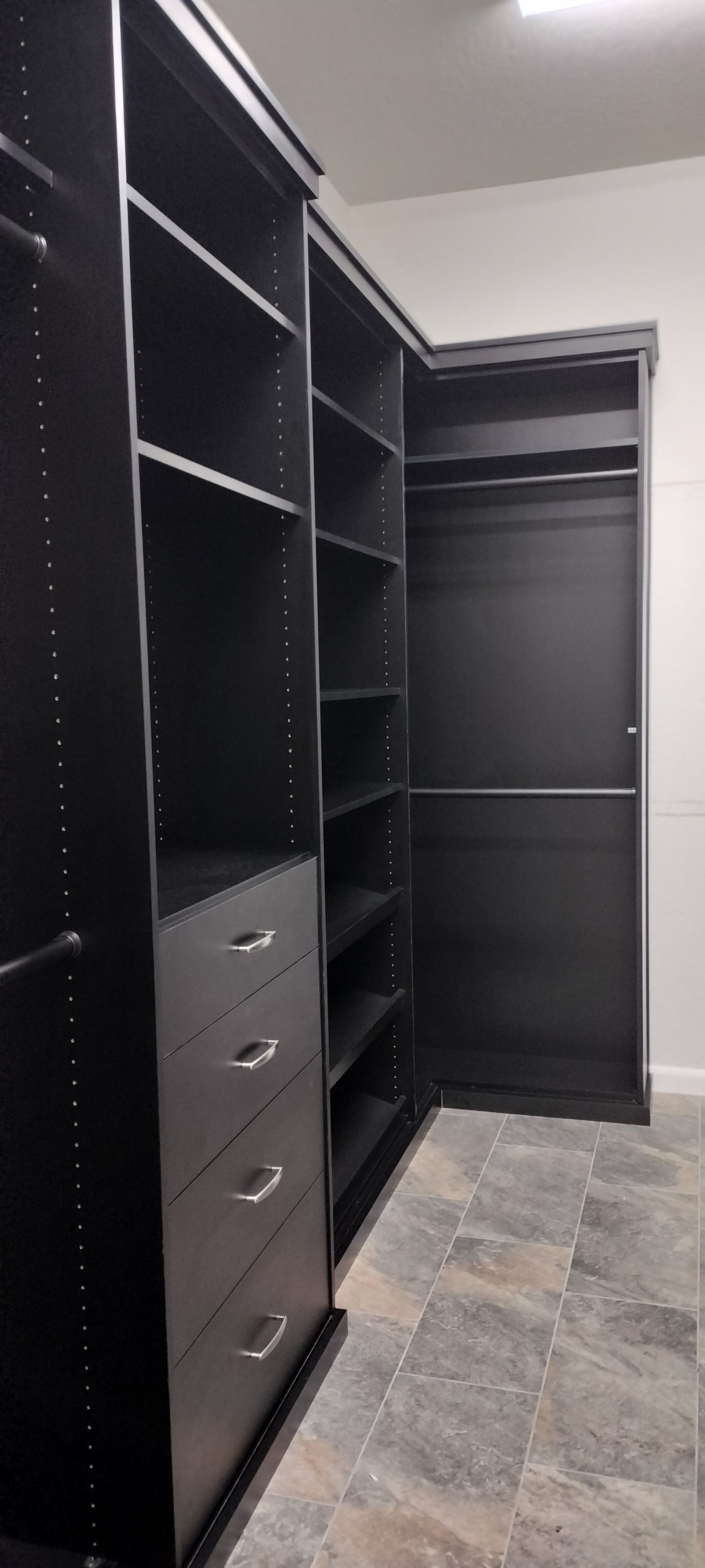 A walk in closet with lots of shelves and drawers.