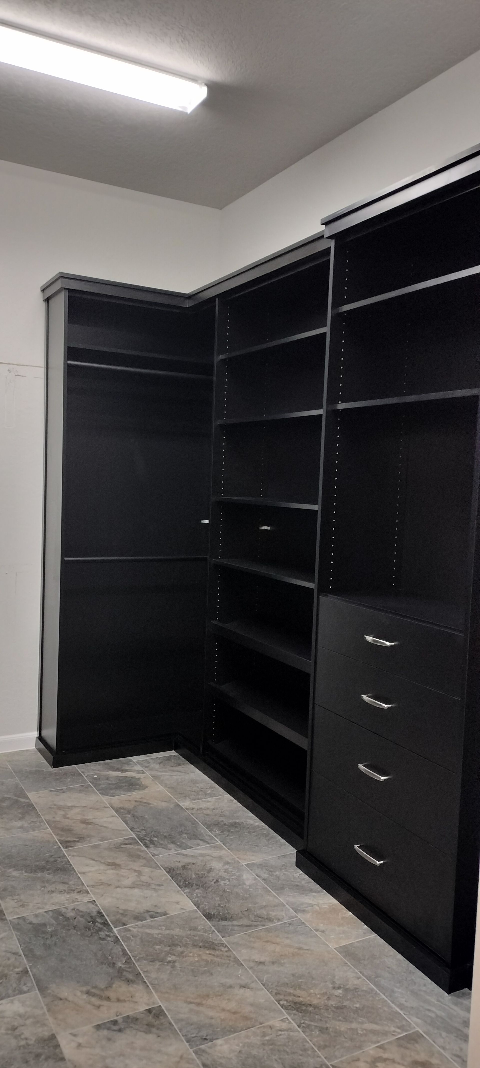 A large walk in closet with lots of shelves and drawers.