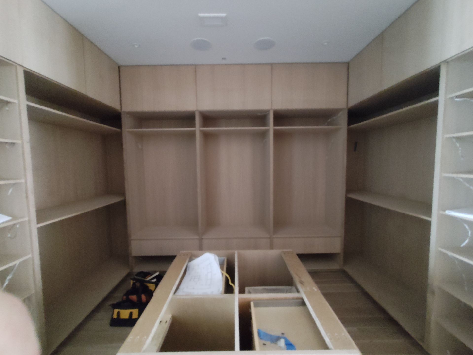 A walk in closet with lots of shelves and drawers.