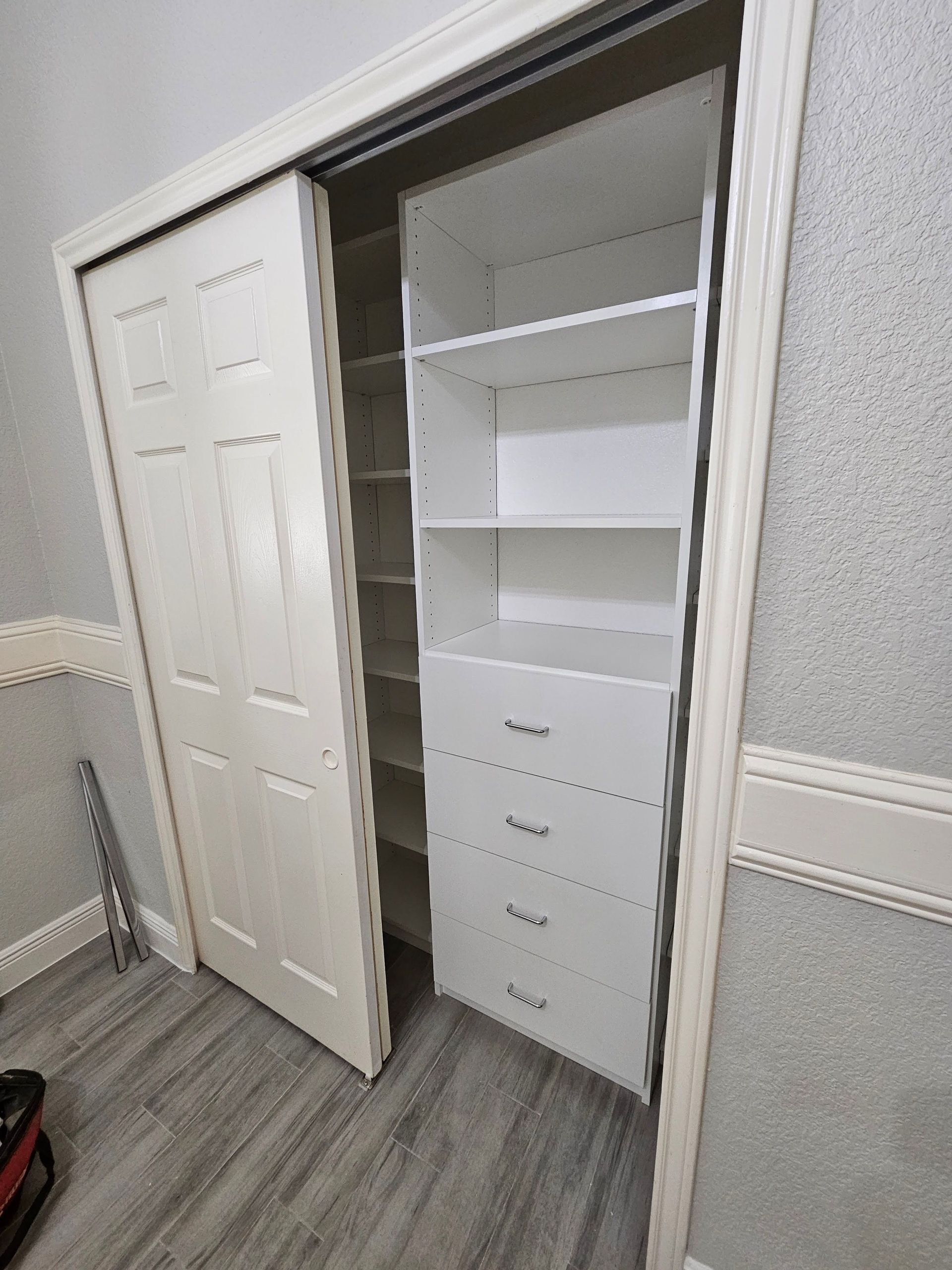 A closet with sliding doors and shelves and drawers.