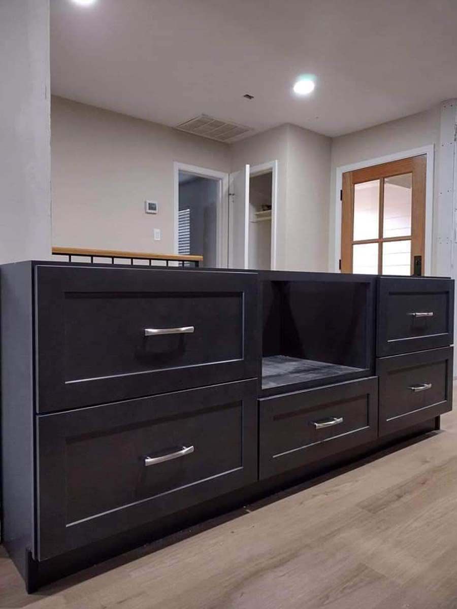 A long black cabinet with drawers in a living room.