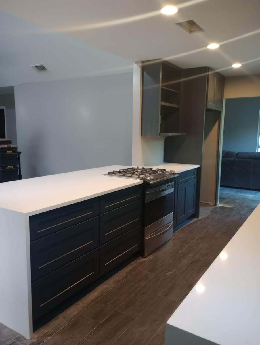 A kitchen with black cabinets and white counter tops